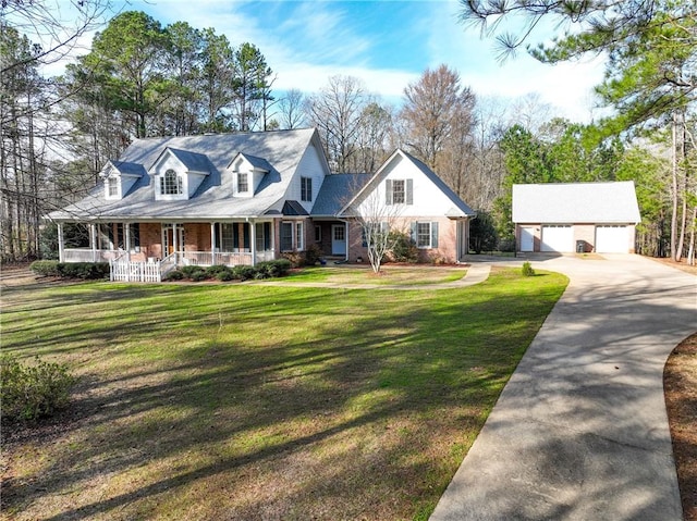 cape cod-style house with an outbuilding, brick siding, a detached garage, a porch, and a front yard