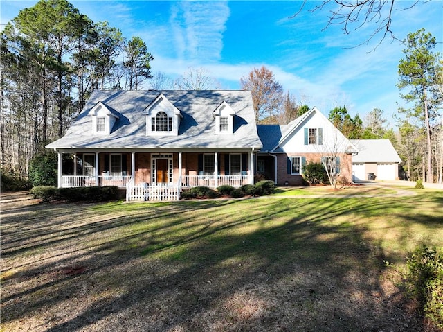 cape cod home featuring covered porch, a front lawn, and brick siding