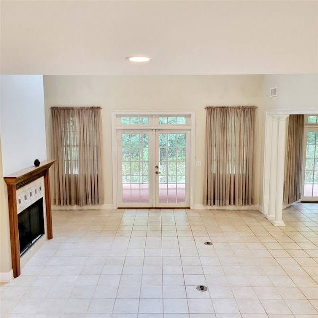1155 County Road 517, Lanett, AL 36863 - unfurnished living room with a tiled fireplace, light tile patterned floors, and french doors