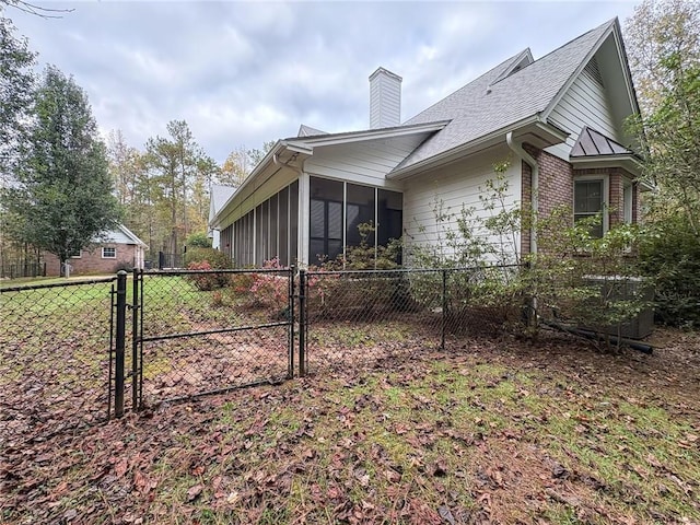 1155 County Road 517, Lanett, AL 36863 - view of side of property with a sunroom, a gate, a chimney, and a shingled roof