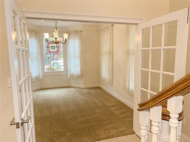 carpeted empty room with a chandelier