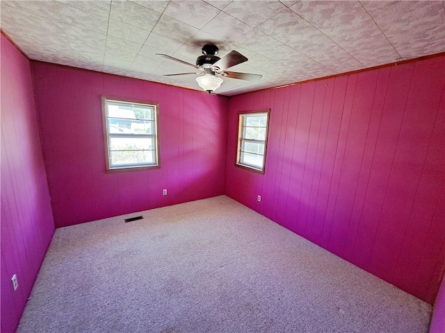 735 Willow St, Alexander City, AL 35010 - carpeted spare room with visible vents, a ceiling fan, and wooden walls