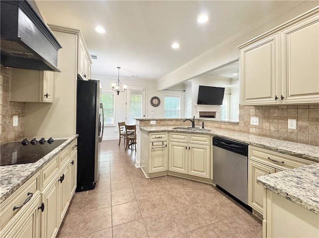 kitchen featuring appliances with stainless steel finishes, cream cabinets, a sink, ventilation hood, and ornamental molding