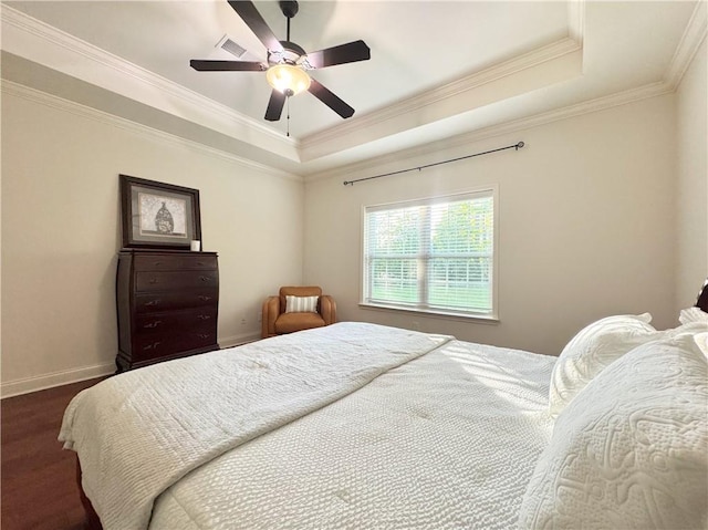 bedroom featuring a tray ceiling, crown molding, baseboards, and a ceiling fan