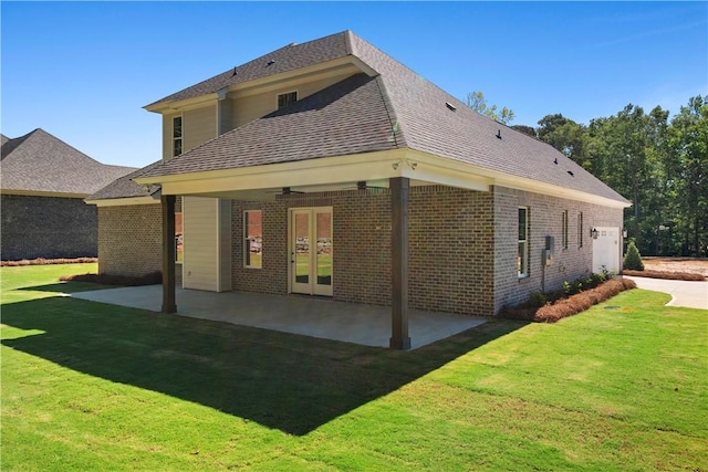 rear view of property featuring a lawn, ceiling fan, a patio, and french doors