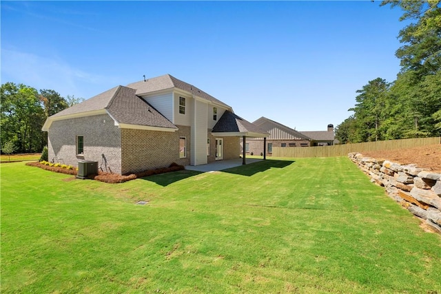 rear view of house with central AC, a yard, and a patio