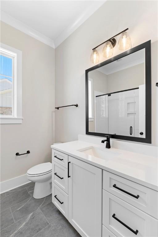 bathroom featuring vanity, toilet, ornamental molding, and walk in shower