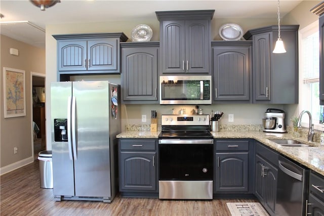 346 Waverly Ln, Jacksons Gap, AL 36861 - kitchen with stainless steel appliances, wood finished floors, light stone countertops, hanging light fixtures, and gray cabinetry