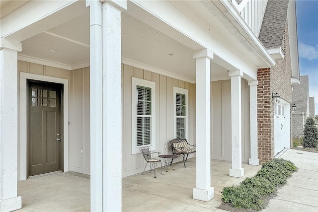 entrance to property with covered porch, board and batten siding, and a shingled roof