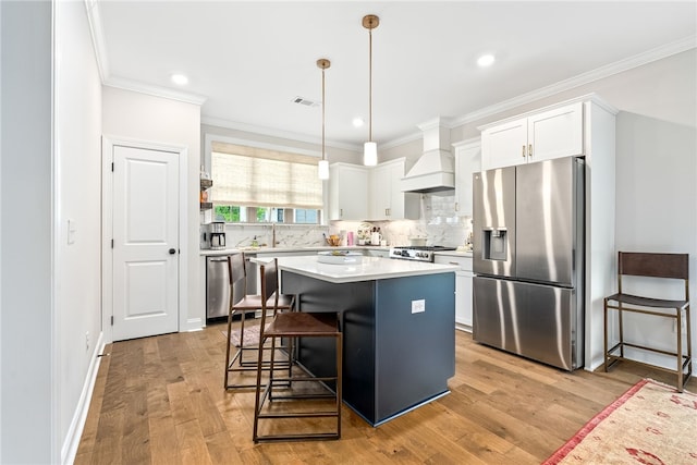 2402 Furlong Trl, Auburn, AL 36830 - kitchen with appliances with stainless steel finishes, premium range hood, crown molding, backsplash, and light countertops