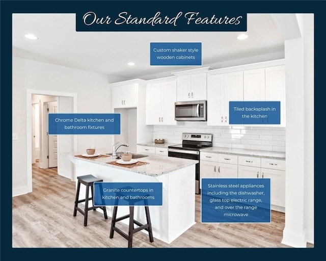 kitchen with white cabinetry, stainless steel appliances, a breakfast bar, and a center island with sink