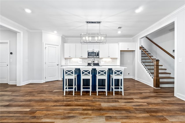 3053 Mimms Trail Rd, Auburn, AL 36832 - kitchen with stainless steel microwave, white cabinetry, baseboards, a kitchen bar, and recessed lighting