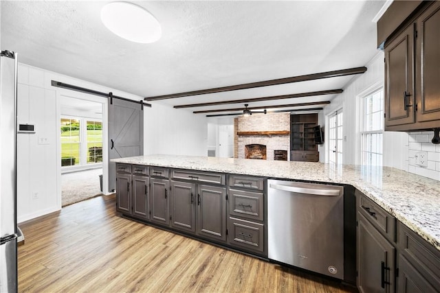 2 Lakewood Cir, Phenix City, AL 36867 - kitchen featuring stainless steel dishwasher, light wood finished floors, a barn door, light stone countertops, and a peninsula