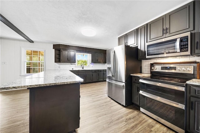 2 Lakewood Cir, Phenix City, AL 36867 - kitchen with stainless steel appliances, tasteful backsplash, a peninsula, light stone counters, and light wood-type flooring