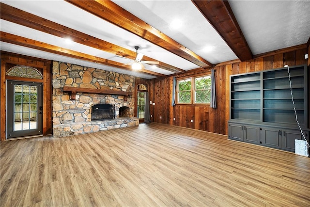 2 Lakewood Cir, Phenix City, AL 36867 - unfurnished living room with ceiling fan, wood finished floors, wood walls, beamed ceiling, and a stone fireplace