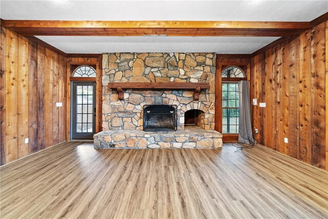 2 Lakewood Cir, Phenix City, AL 36867 - unfurnished living room with beam ceiling, wood finished floors, wooden walls, healthy amount of natural light, and a fireplace