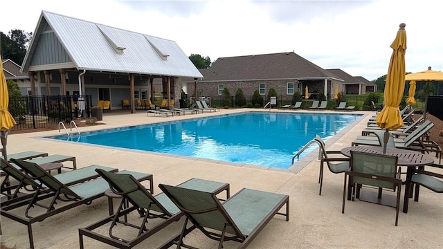 community pool featuring fence and a patio area