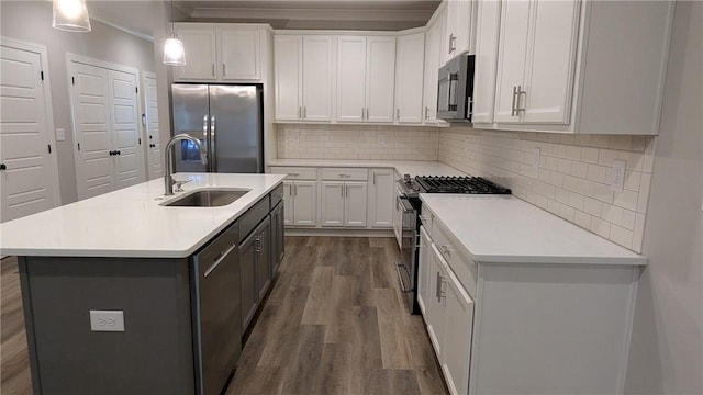 kitchen with white cabinetry, a sink, stainless steel appliances, light countertops, and dark wood-style flooring