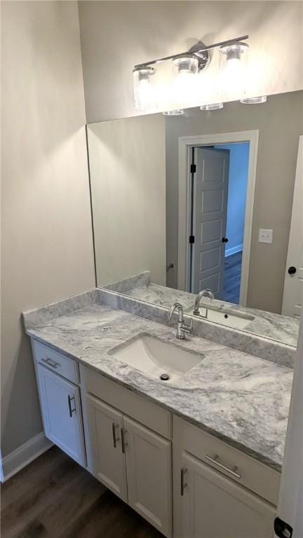 bathroom featuring wood finished floors, vanity, and baseboards