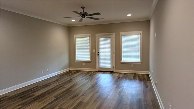 unfurnished room featuring dark wood-style flooring, ceiling fan, crown molding, and baseboards
