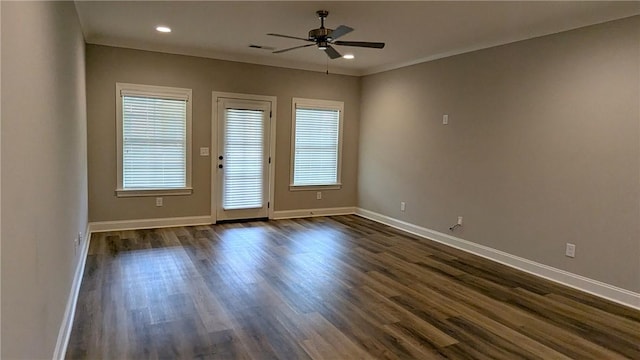 spare room featuring dark wood-style floors, visible vents, ceiling fan, and baseboards