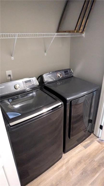 laundry area featuring separate washer and dryer and light wood finished floors