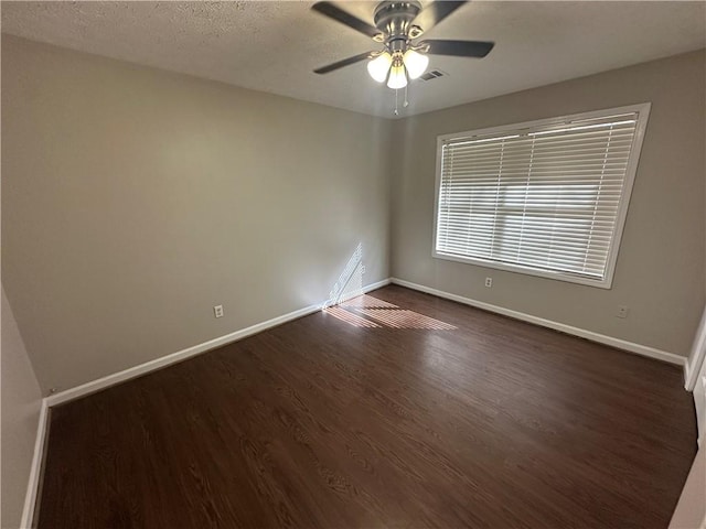 498-500 E University Dr, Auburn, AL 36830 - spare room with baseboards, visible vents, dark wood-type flooring, and a ceiling fan