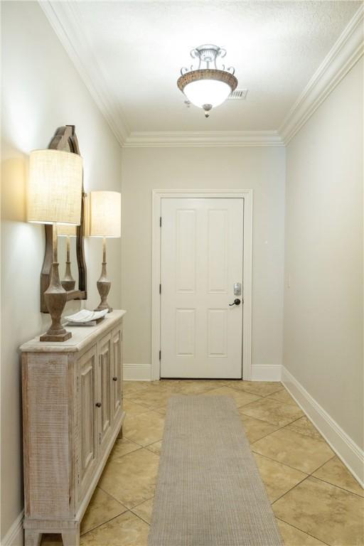 entryway featuring light tile patterned floors and ornamental molding