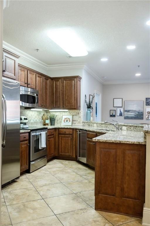 kitchen with light stone countertops, ornamental molding, appliances with stainless steel finishes, tasteful backsplash, and kitchen peninsula