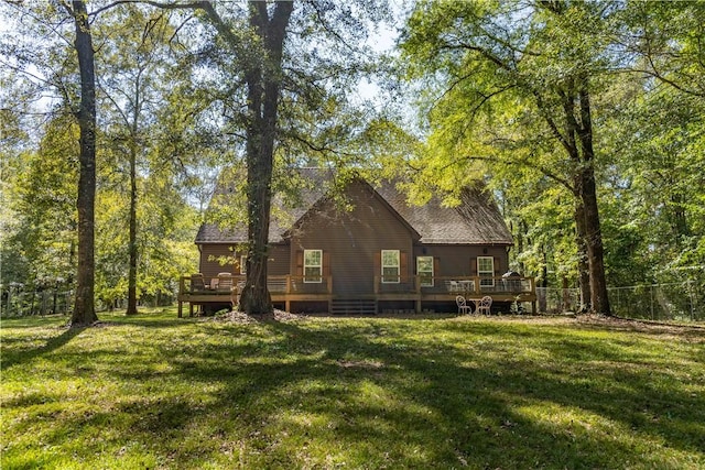 back of house featuring a lawn and a wooden deck