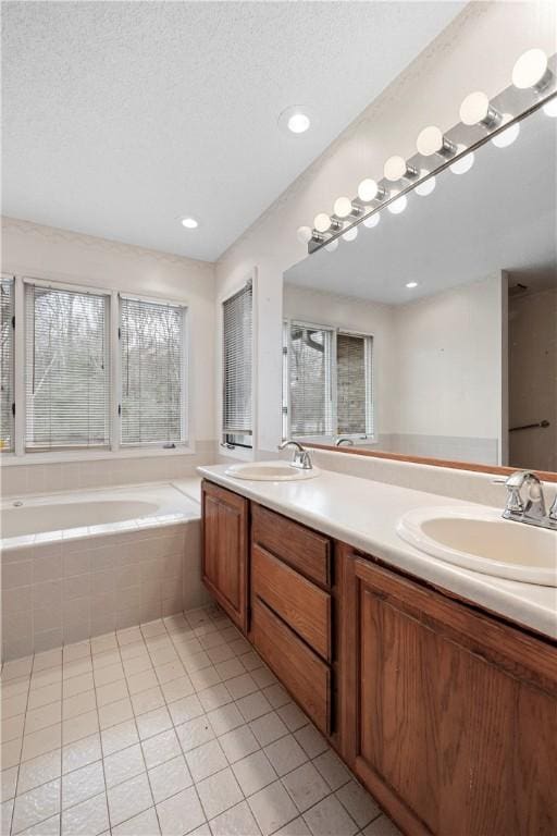 bathroom featuring a garden tub, double vanity, a sink, and tile patterned floors