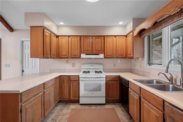 kitchen with wallpapered walls, black dishwasher, white range with gas cooktop, under cabinet range hood, and a sink