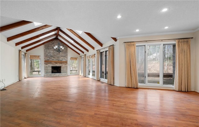 unfurnished living room featuring a notable chandelier, a fireplace, wood finished floors, visible vents, and beam ceiling