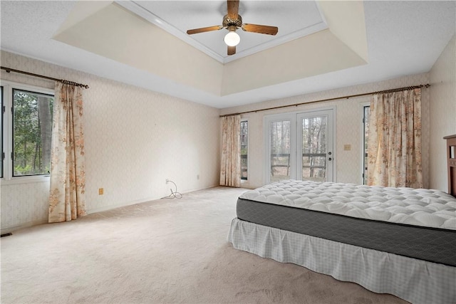 bedroom with carpet, a raised ceiling, access to outside, baseboards, and wallpapered walls