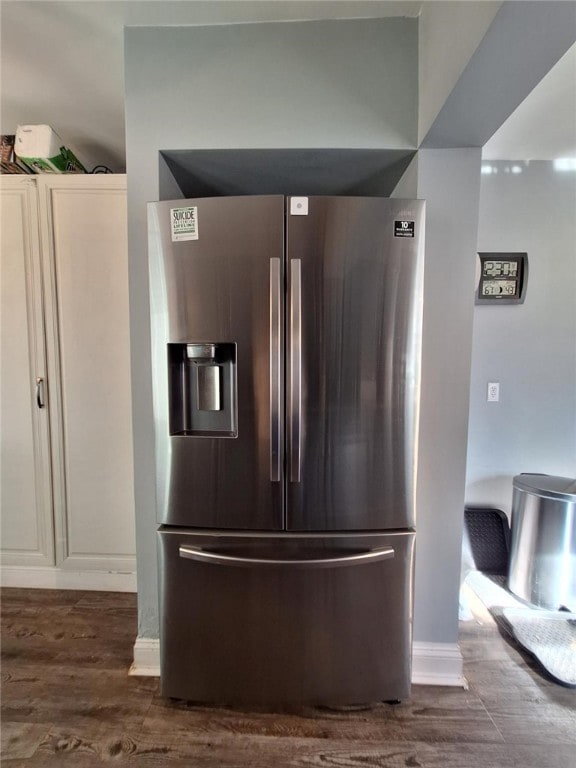 interior details featuring stainless steel refrigerator with ice dispenser and dark wood-type flooring