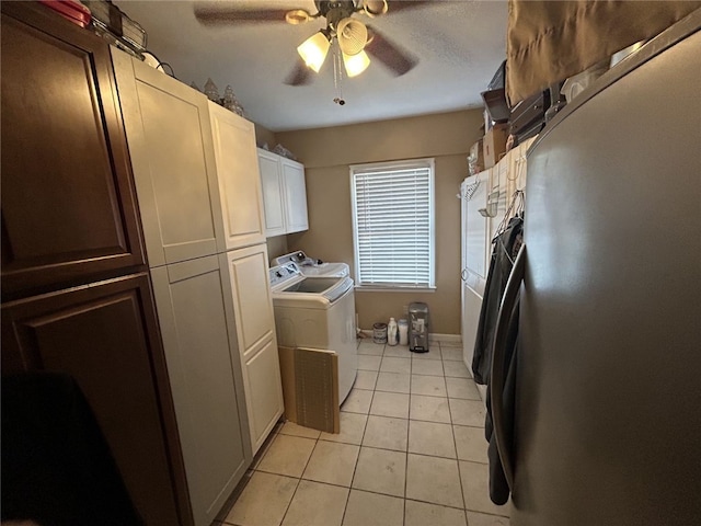 clothes washing area with washing machine and dryer, ceiling fan, light tile patterned floors, and cabinets