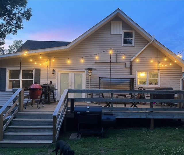 back house at dusk with a deck and french doors