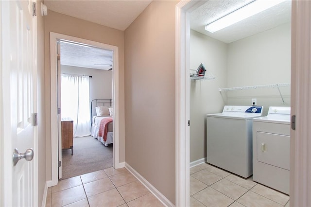 303 N Ross Ave Unit 215, Auburn, AL 36830 - laundry room featuring separate washer and dryer, light tile patterned flooring, and a textured ceiling