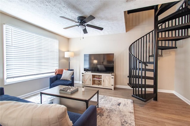 303 N Ross Ave Unit 215, Auburn, AL 36830 - living area featuring ceiling fan, stairway, wood finished floors, plenty of natural light, and a textured ceiling