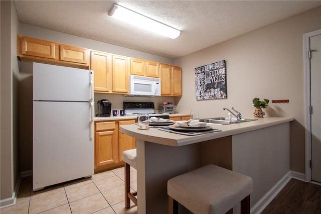 303 N Ross Ave Unit 215, Auburn, AL 36830 - kitchen with white appliances, light brown cabinetry, light countertops, a peninsula, and a textured ceiling