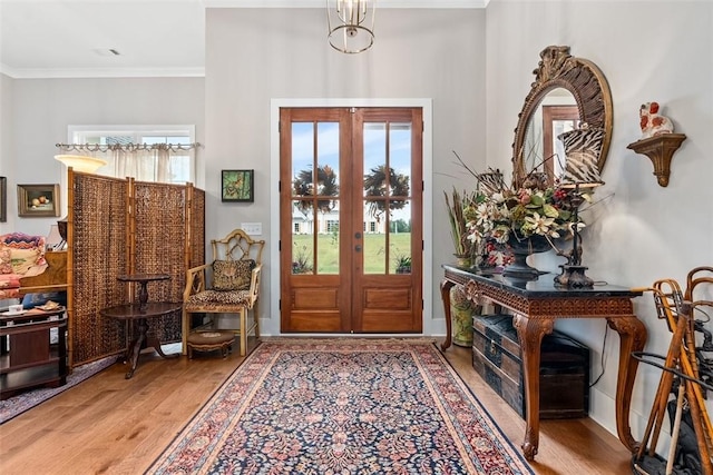 foyer featuring hardwood / wood-style floors, ornamental molding, and french doors