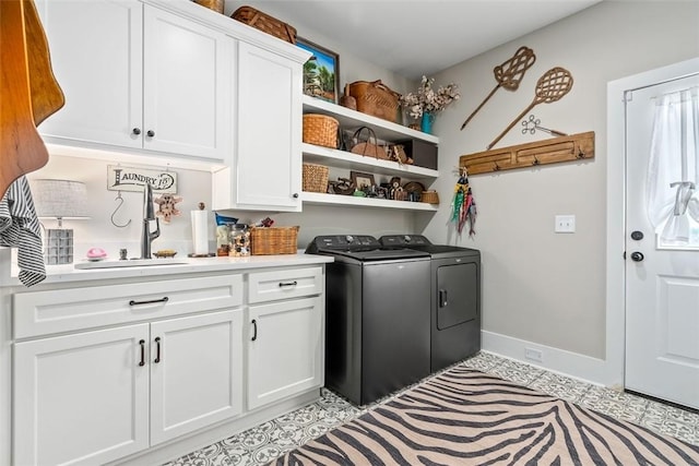 clothes washing area featuring washer and dryer, cabinets, light tile patterned floors, and sink