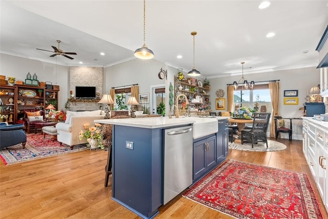 kitchen featuring white cabinets, pendant lighting, a center island with sink, and stainless steel dishwasher