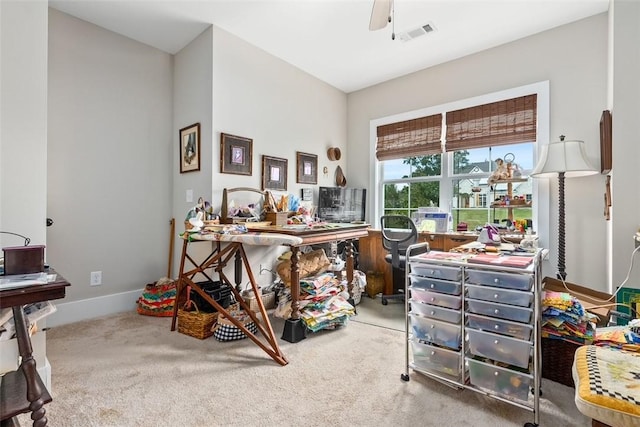 carpeted home office featuring ceiling fan