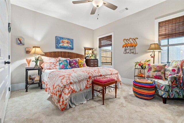 carpeted bedroom with multiple windows and ceiling fan