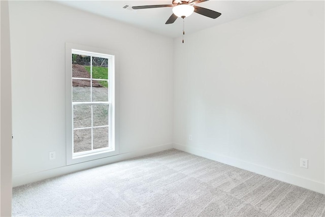 carpeted spare room with ceiling fan and baseboards