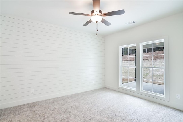 spare room with carpet flooring, visible vents, and a ceiling fan