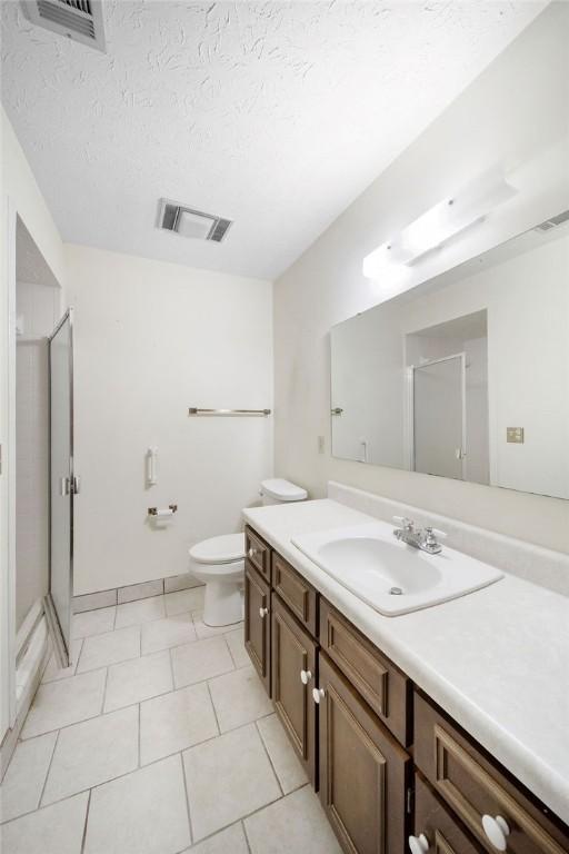 5004 22nd Ave, Phenix City, AL 36867 - bathroom featuring vanity, a shower stall, tile patterned floors, and a textured ceiling