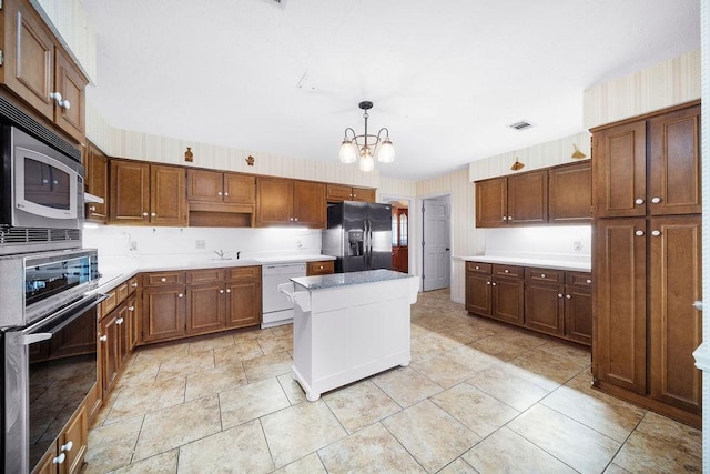 5004 22nd Ave, Phenix City, AL 36867 - kitchen with black refrigerator with ice dispenser, oven, dishwasher, a chandelier, and a kitchen island