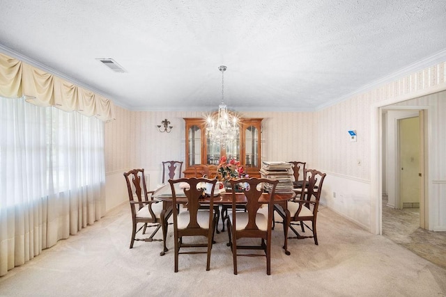 5004 22nd Ave, Phenix City, AL 36867 - dining area featuring crown molding, light carpet, a chandelier, wallpapered walls, and a textured ceiling